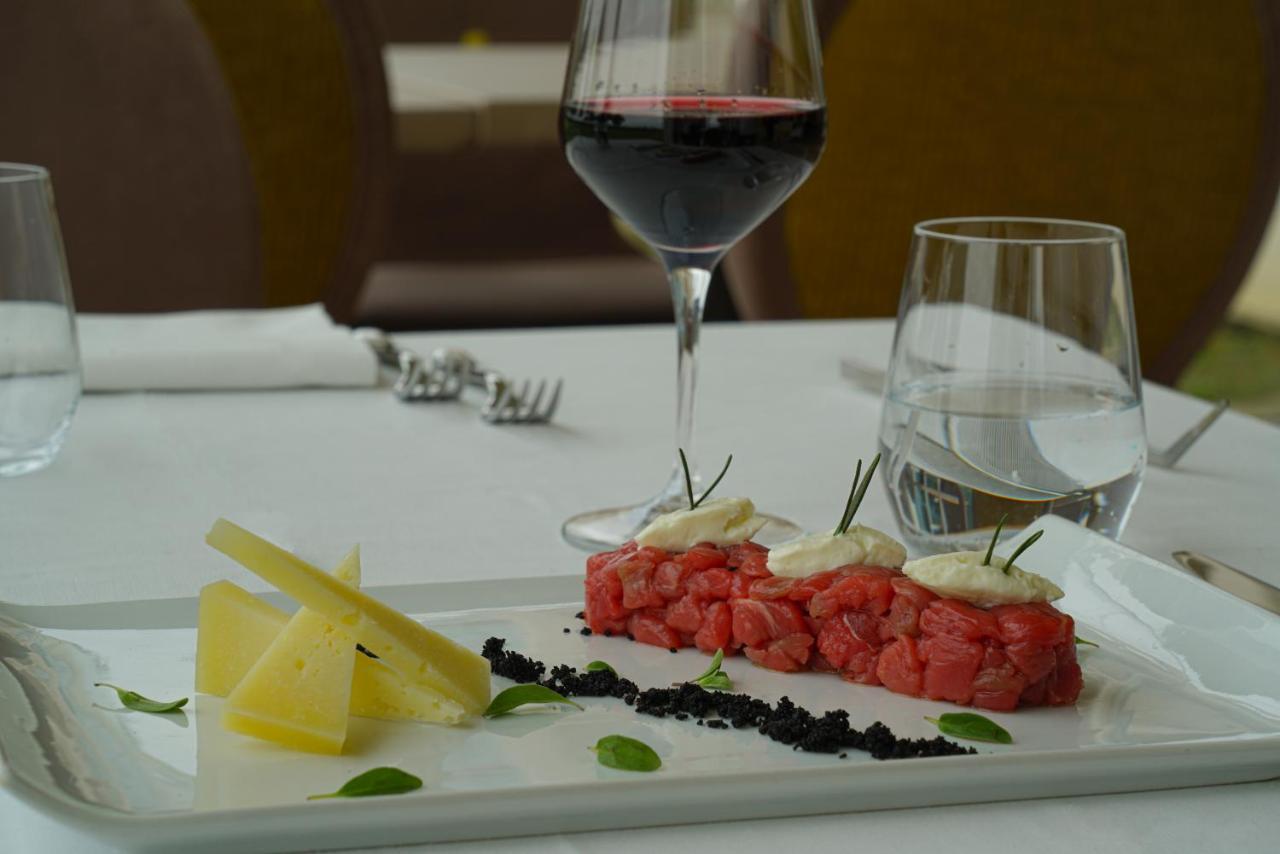 Pisa Tower Plaza Exterior foto A glass of red wine with a plate of tartar